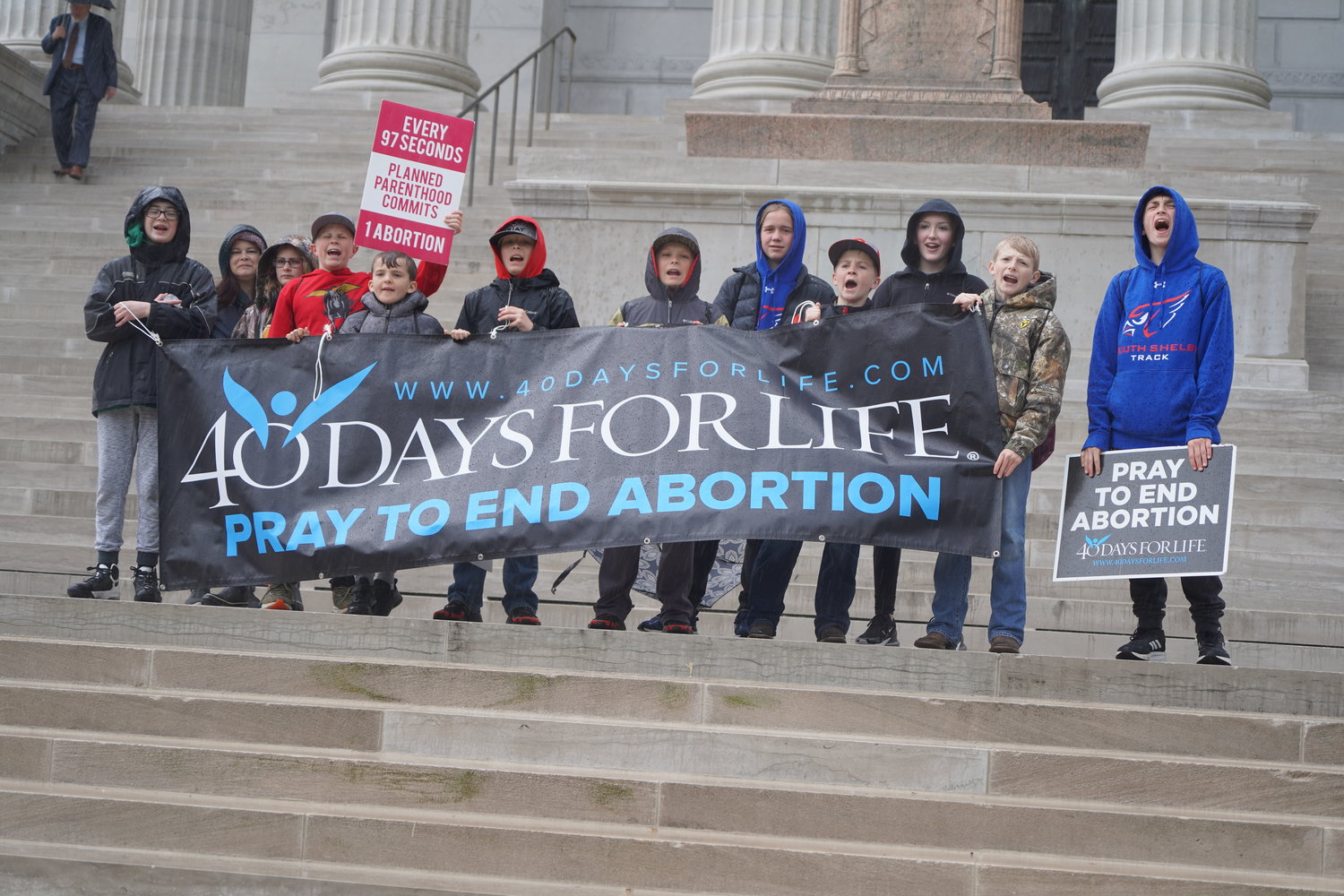 Young people from St. Mary Parish in Shelbina, Immaculate Conception Parish in Macon and St. Patrick Parish in Clarence gather in the rain on the steps of the Missouri State Capitol after marching for life April 20.